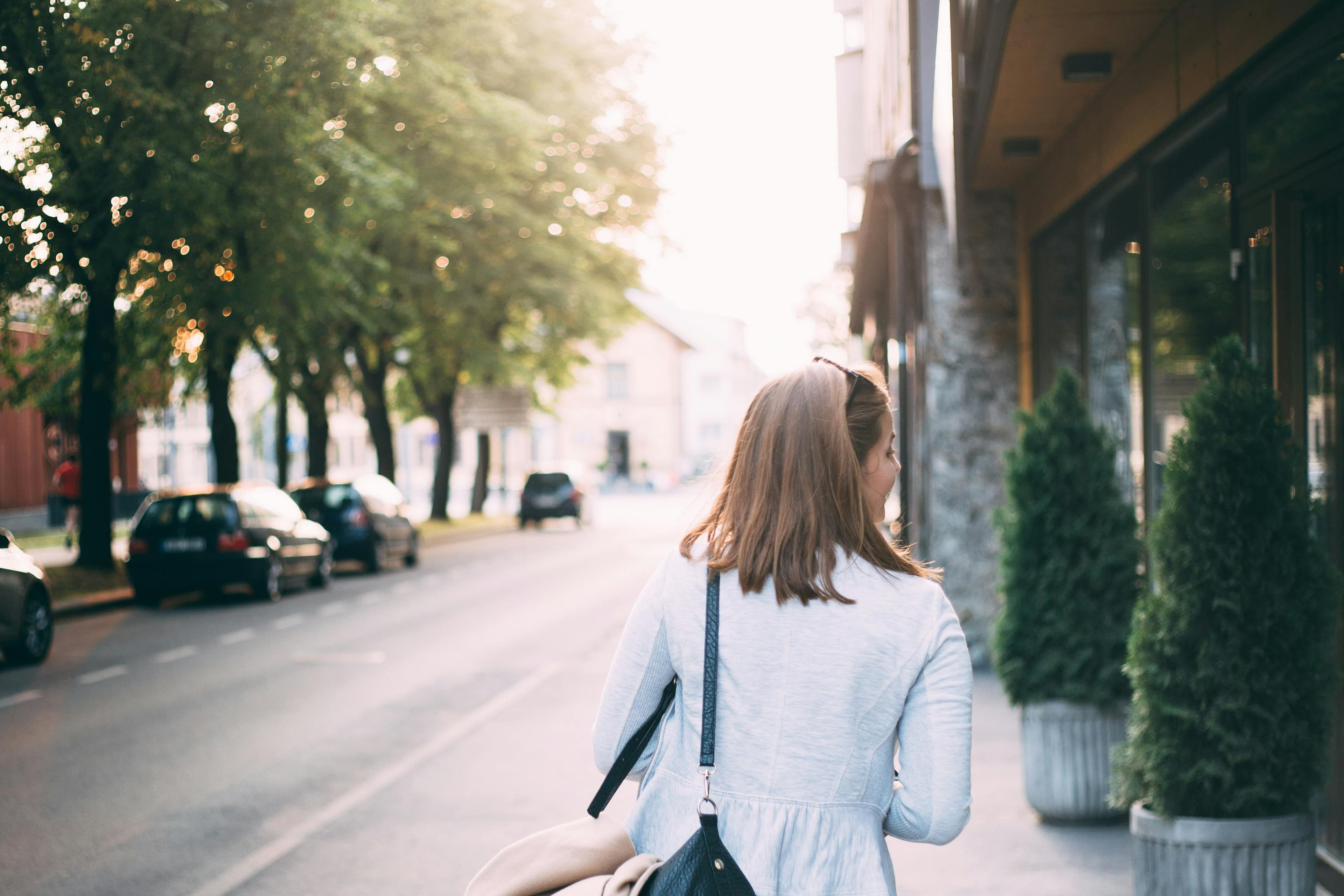 Woman walking down a tree-lined street